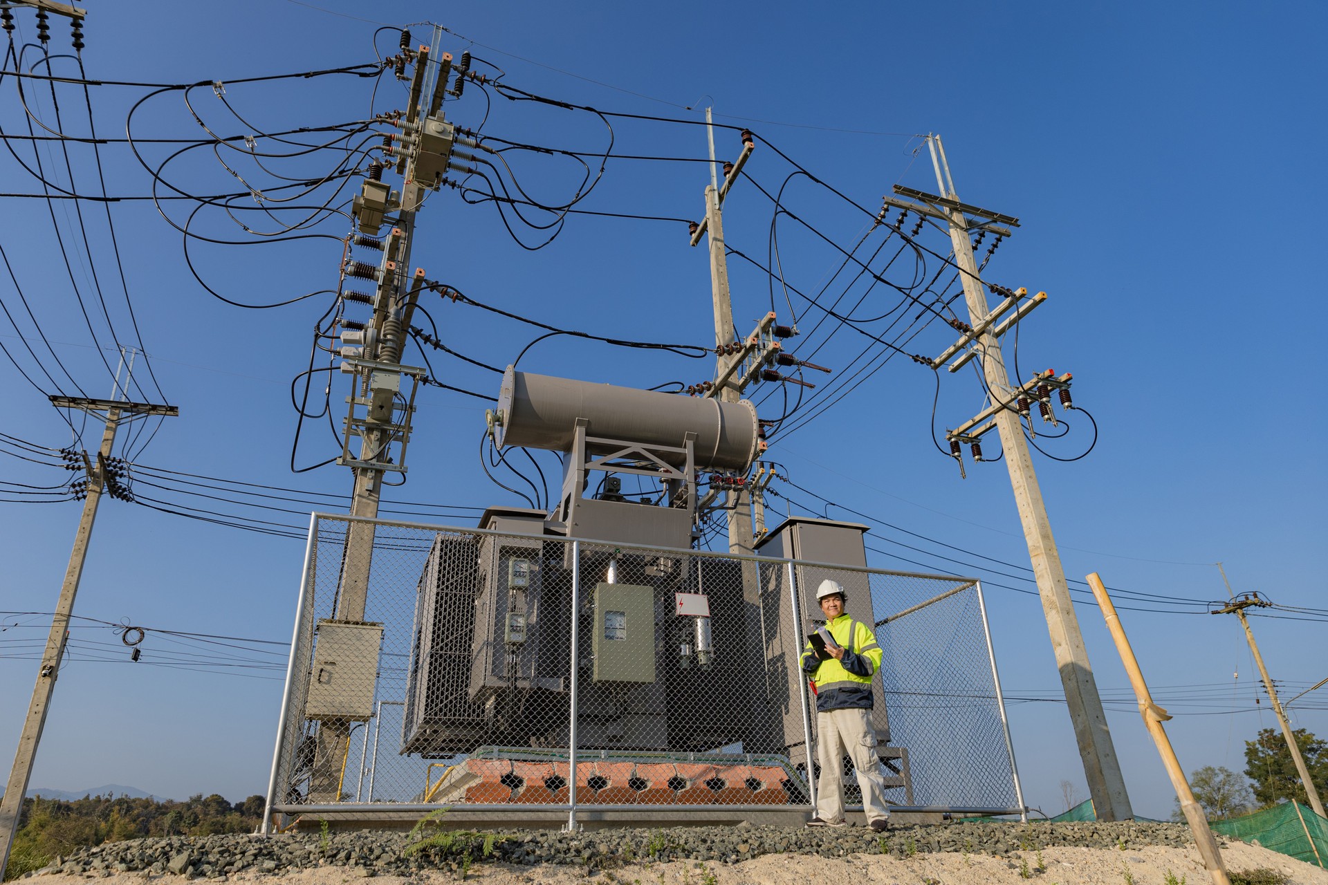 Electrical engineer working in site Electrical engineer man checking Power Distribution Cabinet in the Big Electrical transformer Site.
